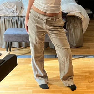 Beige linnebyxor från Melka - Säljer ett par snygga beige linnebyxor från Melka. Byxorna har en klassisk straight passform och är perfekta för både vardag och lite mer uppklädda tillfällen. De har en relativt låg midja. Står ingen storlek men jag som bär plagget har storlek S.