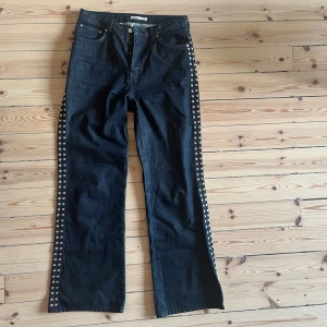 Svarta jeans med nitar - Säljer ett par svarta jeans med coola nitar längs sidorna.  En nit har jag bytt ut hos en skräddare som inte såg skillnad på silver och svart hehe men man tänker inte på det när man har de på! 