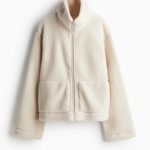 Teddyjacka H&M - HELT SLUTSÅLD jacka i pilé/teddy från H&M. Helt ny med prislappen kvar. Storlek L. Sitter snyggt och lite loose på mig som vanligtvis har strl xs/s.  Men passar nog allt från xs-xl beroende på vilket fit man vill ha.