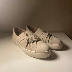 Låga sneakers  - Superbra skick nästan som nya, har använd nästan en halv sommar. Säljer då storleken är för stor på mig (jag har strlk 38/39). Nypris 1299 så lägger ut för 400 men kan förhandla om pris. Beige mocka med volangdetalj:)