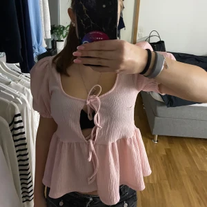 Rosa topp från Gina Tricot - Säljer en supersöt rosa topp från Gina Tricot. Den har korta puffärmar och en knytning framtill som ger en fin detalj. Materialet är mjukt och bekvämt. Toppen är i mycket bra skick, använd ca 3 gånger. Pris kan diskuteras, köpt för 279 kr💙