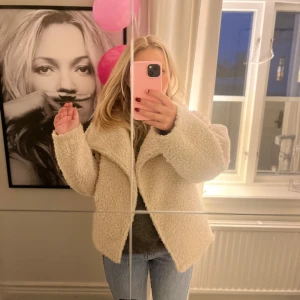Beige teddyjacka från Gina Tricot - Supermysig beige teddyjacka från Gina Tricot i storlek XS. Perfekt för höst och vinter med sin fluffiga och varma design. Jackan har en oversized passform och långa ärmar, vilket gör den både trendig och bekväm. Perfekt för att hålla sig varm och snygg under kyliga dagar! 🧥✨