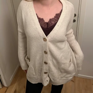 Kofta - Beige kofta med guldknappar, har noppror