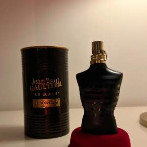 Säljer en elegant parfymflaska från Jean Paul Gaultier, Le Male Le Parfum. Flaskan har en unik design i form av en svart torso med guldiga detaljer. Den kommer i en stilren metallförpackning. Perfekt för den som vill ha en lyxig doftupplevelse. Passar både till vardags och fest! Köpte den för 1000kr och säljer nu för ett rimligt pris! Det finns 70ml kvar av flaskan från att ha varit 75ml.