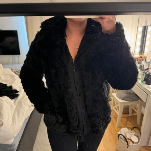Pälsjacka - Svart pälsjacka med fickor, perfekt till vintern. Storlek S-M