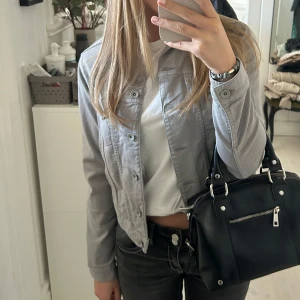 Grå jeansjacka - Säljer en snygg grå jeansjacka i mycket bra skick. Jackan har en klassisk design med knappar framtill och långa ärmar. Perfekt för vår och höst, och funkar både till vardags och fest. Storleken är dam S och den har en normal passform.
