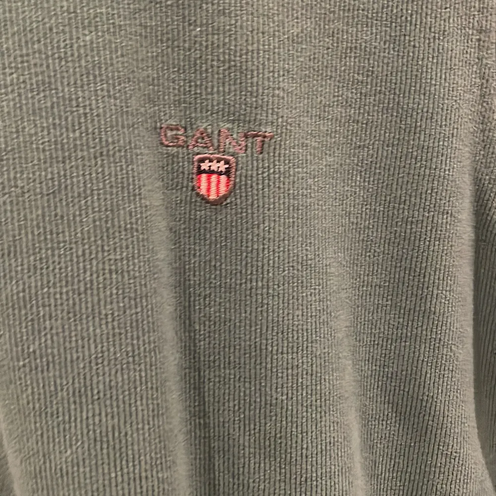 Säljer en snygg grön tröja från GANT i mycket bra skick. Den har en liten broderad logga på bröstet och ribbade muddar vid ärmslut och nederkant. Perfekt för både vardag och lite finare tillfällen. Passar bra till jeans eller chinos!. Neuletakit & Villapaidat.