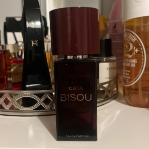 Caia bisou parfym  - Parfym från CAIA, knappt använd. En träig, blommig och feminin doft.  Parfymen har en väldigt unik doft som jag inte känt tidigare så man kan helt klart känna sig speciell när man bär den!! 