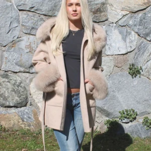 Beige kappa med pälsdetaljer - Säljer en superfin beige kappa med fluffiga pälsdetaljer på krage och ärmar. Den har ett bälte i midjan för en snygg passform och stora fickor fram. Perfekt för  vinter när du vill hålla dig varm och stilren. Passar både till vardags och fest! Nypris på Furofstockholm är 2399kr