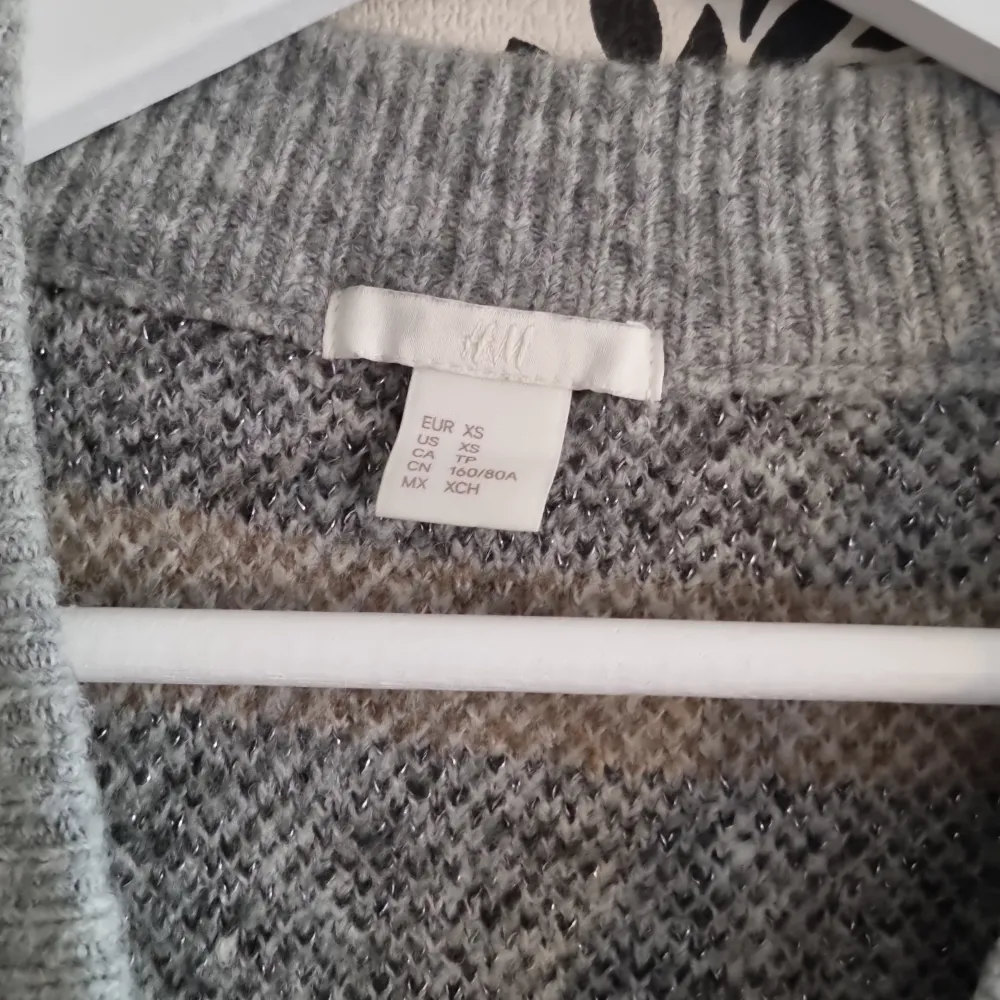 Säljer en supermysig grå tröja från H&M i storlek XS. Den har ett snyggt mönster i olika grå nyanser och är perfekt för kyliga dagar. Tröjan är tillverkad i en mjuk blandning av akryl, polyester och ull, vilket gör den både varm och bekväm. Passar perfekt till både vardag och mysiga hemmakvällar.. Neuleet.