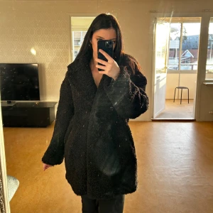 H&M - Oversized Teddy Jacka  - Mysig svart teddyjacka perfekt för kalla dagar. Den har en oversized passform och långa ärmar, vilket gör den superbekväm och trendig. Jackan är i mycket bra skick och passar perfekt för höst och vinter. Den har en klassisk design med stora slag och är gjord av mjukt teddy-material. Använd endast ett par gånger under vintern men har inga felaktigheter, ser ren ut.