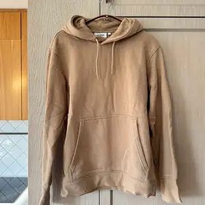 Säljer en snygg beige hoodie från Weekday i mycket bra skick. Den är supermjuk och perfekt för höst och vår. Har en klassisk känguruficka och justerbar huva med dragsko. Perfekt för en avslappnad stil!