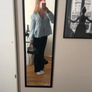 Svart handväska med dragkedja - Säljer en snygg svart rymlig handväska i skinn med dragkedja framtill och ett fack inuti. Väskan har både handtag och en avtagbar axelrem, vilket gör den superpraktisk för alla tillfällen. Perfekt för både vardag och fest! Vet ej vart den kommer ifrån!