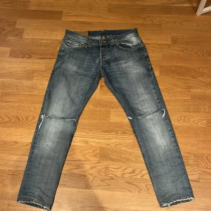 Blå jeans från Dondup - Säljer ett par feta  blå jeans från Dondup i storlek 31. De har en cool slitning vid knäna och en klassisk femficksdesign. Perfekta för en chill stil med en touch av edge. Passar bra till både vardag och fest! Ba o hör av er om det finns några frågor👍🤝
