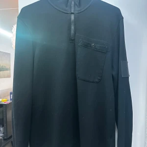 Svart tröja från Peak Performance - Säljer en stilren svart tröja från Peak Performance i storlek M. Tröjan har en praktisk dragkedja vid halsen och en ficka på bröstet. Perfekt för både vardag och träning. Den är i mycket bra skick och redo för nya äventyr!