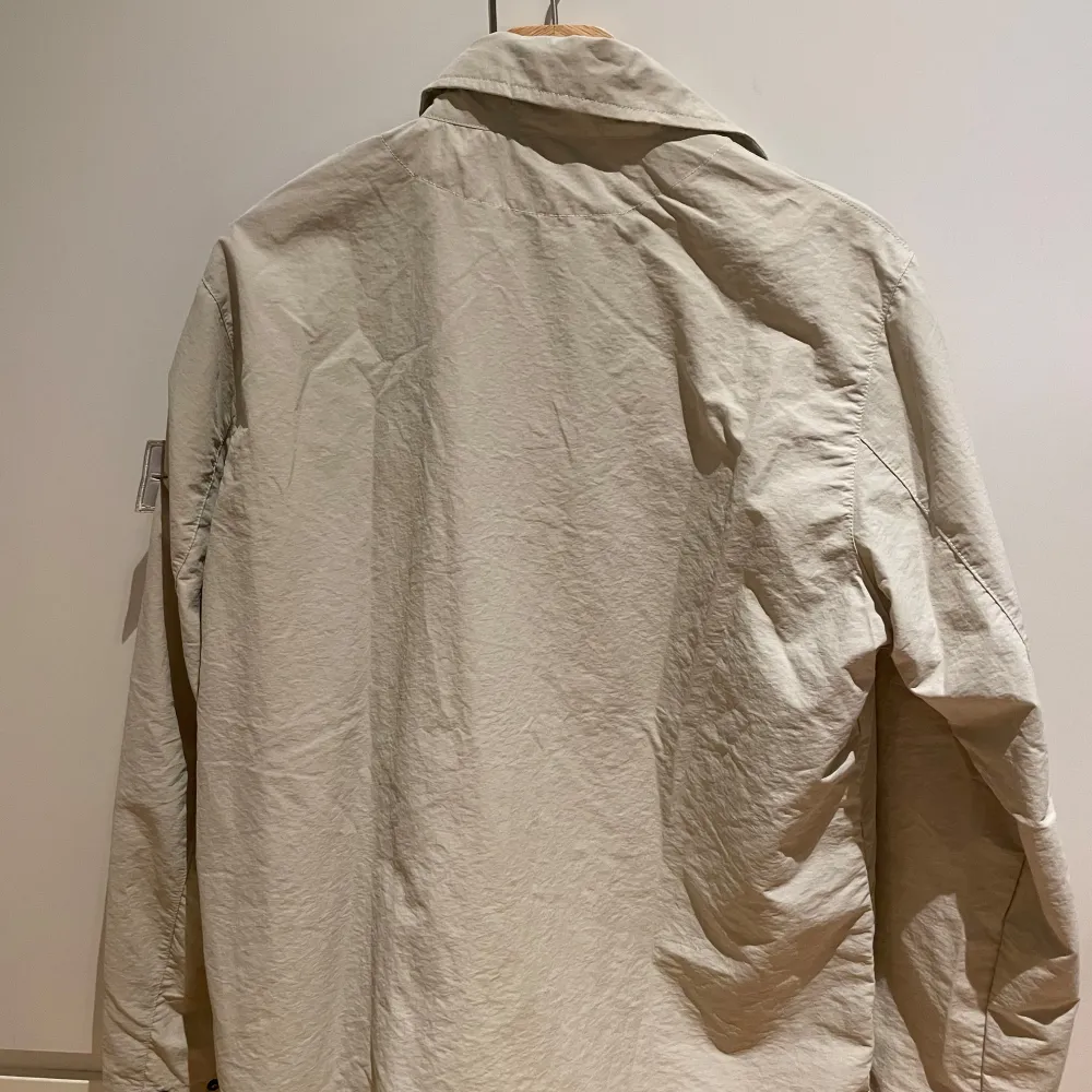 Säljer en snygg beige jacka från Stone Island. Den är i riktigt bra skick och storlek M. Perfekt för vår och höst! Kan inte garantera äkthet men koden går att skanna. Släng iväg ett prisförslag om priset inte passar.. Jackor.