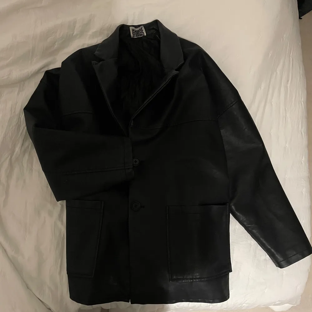 Säljer en svart skinnjacka från Reclaimed Vintage i storlek S. Jackan har en klassisk design med knappar framtill och stora fickor. Perfekt för höst och vår, och ger en cool vintage-look. Passar både till vardags och fest!. Takit.