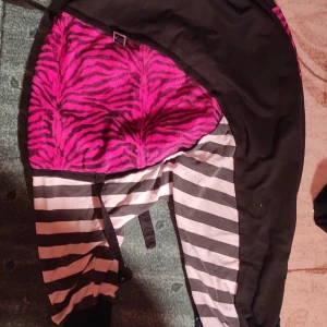 Old visual kei/ Svarta och rosa byxor med zebramönster - Coola byxor med svart bas och rosa zebramönster på fickorna. De har också svartvita ränder på benen och en snörning framtill. Perfekta för en unik och djärv stil! Det är en japansk stil och en slags streetfashion blandat med lite gammal visual kei. 