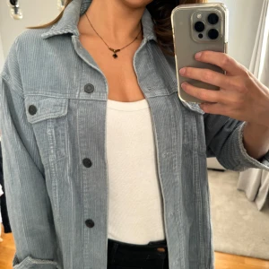 Ljusblå manchesterjacka - Säljer en snygg  manchesterjacka i mycket bra skick. Den har en avslappnad passform med långa ärmar och knappar framtill. Perfekt för höst och vår, och funkar både till vardags och lite mer uppklädda tillfällen. Storleken är dam xs.