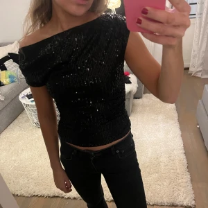 Glittertopp  - Säljer denna svarta Glittertopp från shein. Den är aldrig använd, endast provad och därför i super skick. Liknar den från vero moda men är ej öppen i ryggen. Storlek XS, perfekt till fest eller andra tillställningar!