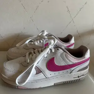  Nike gamma force sneakers i vitt med rosa detaljer. Stl 36,5. Använda ett fåtal ggr, fint skick förutom någon enstaka liten obehandlad fläck/slitning.