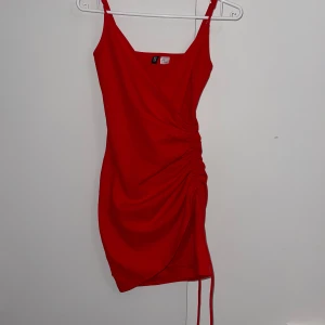 Röd festklänning - Perfekt kombination av stil och självsäkerhet. Framhäver former på ett smickrande sätt. Den fina färgen gör att du sticker ut! 