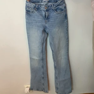 Ljusblå jeans med bootcut - Säljer ett par ljusblå jeans med bootcut. De har en klassisk femficksdesign och är i en snygg, tvättad ljusblå färg. Perfekta för en avslappnad vardagslook!