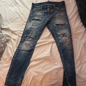 Blå jeans från Dsquared2 - Säljer ett par snygga blå jeans från Dsquared2 i storlek 44. De är inte så mycket använda, men klart så har dom använts. Skriv i pm för mer info och kvitto!