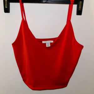 Röd linnetopp från Amisu - Säljer en snygg röd linnetopp från Amisu. Toppen har en v-ringad design och är ärmlös med smala axelband. Perfekt för sommardagar eller en kväll ute. Materialet känns mjukt och bekvämt.