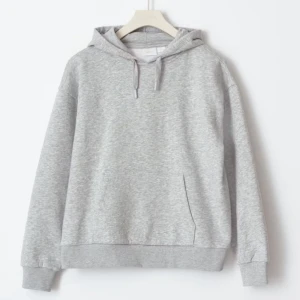 Grå hoodie Gina - Säljer en klassisk grå hoodie med justerbar huva och känguruficka framtill. Perfekt för en avslappnad stil. Mjuk och bekväm med ribbade muddar vid ärmslut och nederkant.