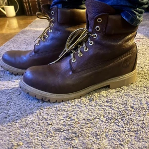 Bruna Timberlands - Säljer ett par robusta bruna kängor från Timberland med snörning och kraftig sula. Perfekta för höst- och vinterväder.