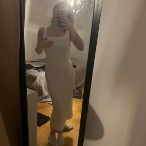 Vit tight klänning - Säljer en stilren vit klänning med en tight passform. Perfekt för sommarens varma dagar. Klänningen har en enkel och elegant design som passar till många tillfällen. Lite räfflad