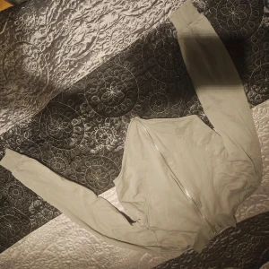 Beige crop top från NLY Trend - Snygg beige crop top från NLY Trend med dragkedja framtill. Perfekt för en stilren look med långa ärmar och en croppad design som ger en modern touch.