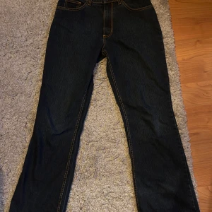 Mörkblå bootcut jeans från Hero by Wrangler - Säljer ett par mörkblå bootcut jeans från Hero by Wrangler. De har en klassisk femficksdesign och kontrasterande sömmar. Perfekta för en avslappnad stil.
