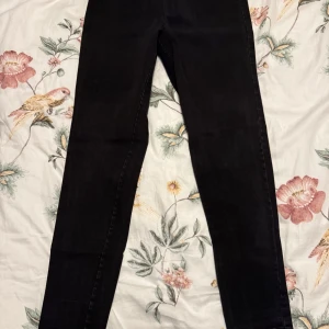 Svarta byxor från Masai - Snygga svarta byxor från Masai i storlek S. Byxorna har en elastisk midja för extra komfort och en stilren design utan synliga detaljer. Perfekta för en minimalistisk look.