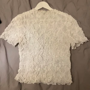 Vit kortärmad topp med textur - så gullig topp från Vero Moda med resår så väldigt stretchig, fint skick 