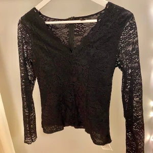 Svart spetsblus från Amisu - En svart spetsblus från Amisu med långärmad design och v-ringad hals. Använd nån få gång så i väldigt bra skick, har en dragkedja där bak. 💗