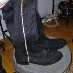 Svarta höga stövlar från New Look - Snygga svarta stövlar från New Look med dragkedja på sidan. Perfekta för en stilren look och passar bra till både jeans och chinos och fest och till vardags.