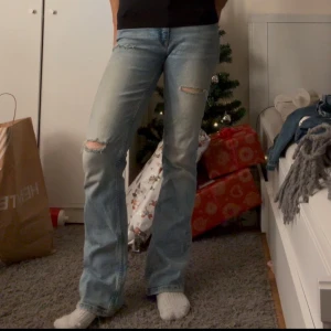 Ljusblå bootcut jeans - Säljer ett par ljusblå bootcut jeans med slitningar på knäna, barn storlek 164 men passar mig som vanligtvis har W26 L30