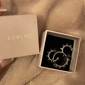 Silvriga örhängen och ring med nitar från Edblad - Snygga silvriga örhängen och ring från Edblad. Kommer i originalförpackning. Tryck ej på köp nu innan du har kontaktat mig!!❤️