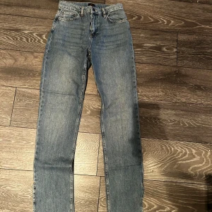 Blå jeans från NLY - Snygga blå jeans från NLY med en klassisk femficksdesign. De har en rak passform och är högmidjade, vilket ger en tidlös look. Perfekta för en avslappnad stil. Ej använda, bara testade