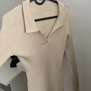 En lång skjort-klänning  - En beige klänning 