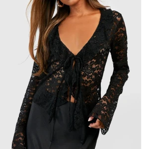 Svart spetstopp - Fin svart spetstopp med knytning fram i storlek 38! Använd endast en gång och därför som ny💕Med knytningen framtill kan man justera storlek bra. Säljer för 120kr!