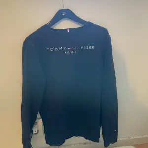 Säljer en blå Tommy Hilfiger tröja. Använd tröja med fläckar på rygg (se bild).  Storlek: 164