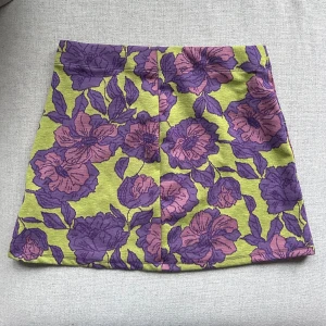 Blommig kjol i grönt och lila från Zara - Snygg kjol med blommigt mönster i grönt och lila från Zara. Kjolen är i bra skick, använd en gång och är i storlek M🥰