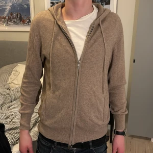 Soft goat Kashmir hoodie  - Snygg soft gott zip hoodie i färgen toast. Hyfsat nyköpt och inte använd så mycket. Den är i mycket bra skick förutom att lappen lossnat i det ena hörnet. Killen på bilderna är 180. Priset kan diskuteras.