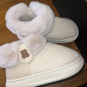 Beige uggs med pälsdetalj - Mysiga beige uggs med mjuk pälsdetalj runt ankeln. Perfekta för att hålla fötterna varma under kalla dagar. storleken är 40-41 men passar mig som har 39 med. Pris kan diskuteras. Använd 1 gång 