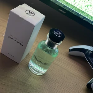 Imagination Eau de Parfum från Louis Vuitton - Säljer en flaska Imagination Eau de Parfum från Louis Vuitton. Flaskan är elegant med en genomskinlig design och svart lock. Parfymen är 100 ml och tillverkad i Frankrike. Perfekt för den som vill ha en lyxig doftupplevelse.