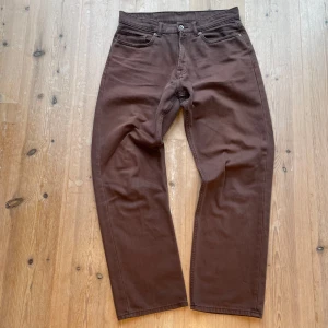 Bruna byxor från Vailent - Snygga bruna byxor från Vailent i en klassisk straight stil. Byxorna har en midwaist design och är tillverkade i bomull. Som vanligt är den med fem fickor och knappgylf. En snygg sliten look på dom. Storlek S som typ motsvarar 31/31. Skriv vid frågor!