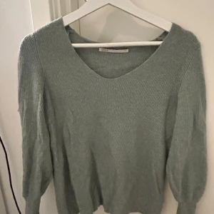 Grå ribbad tröja från ONLY - Säljer en stilren grå ribbad tröja från ONLY. Tröjan har en v-ringad hals och långa ärmar, perfekt för en avslappnad look. Passar bra till både jeans och kjol. 